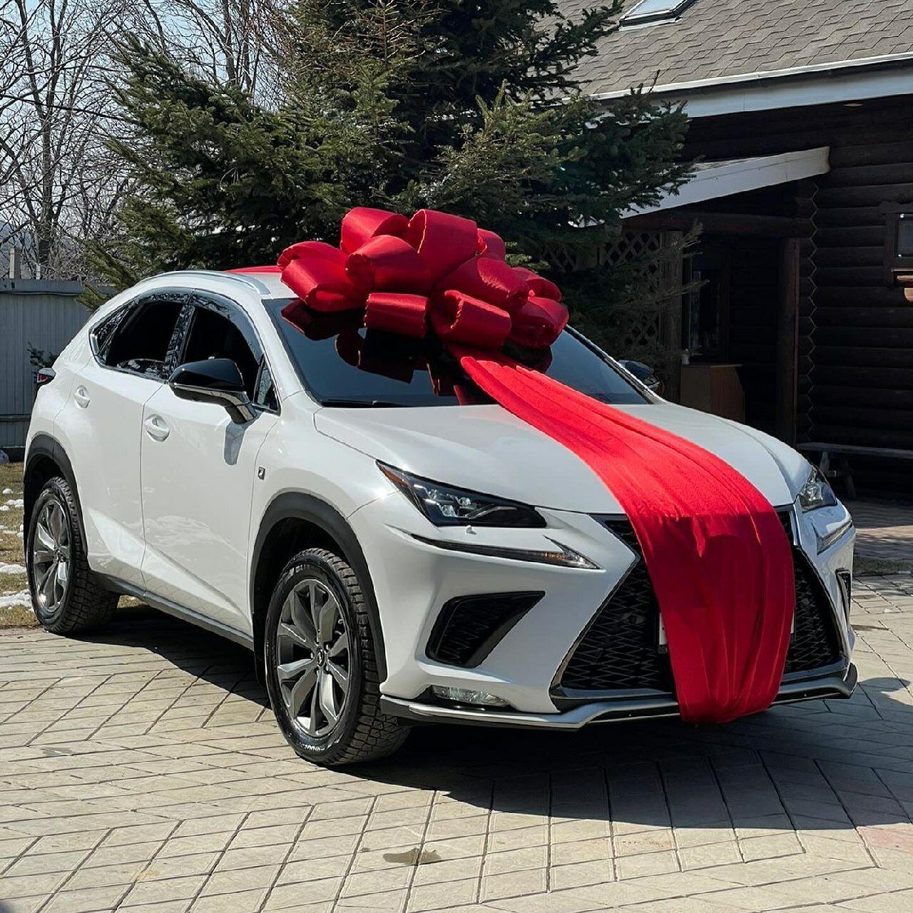 Белый автомобиль с красным бантом и лентой